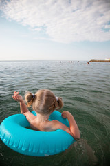 Little girl swimming with inflatable circle