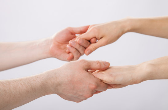 Two pairs of hands holding each other