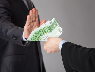 Confident businessman rejecting an offer of money