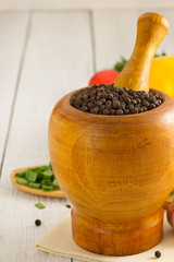 mortar with pestle and spices on wood