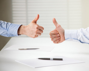 Successful business people showing thumbs up sign