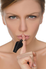 young woman holding finger and whistle before lips