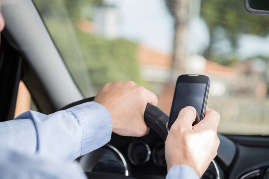 Man with mobile and driving