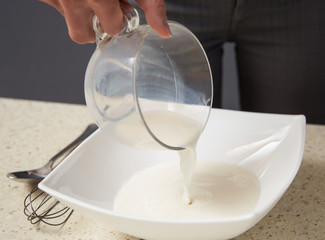 Housewife filling milk in a bowl