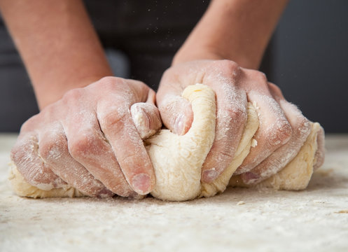 Woman's hands knead dough