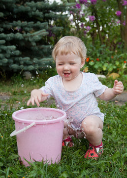 Charming baby girl playing with water