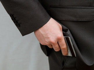 Businessman putting a credit card in a pocket