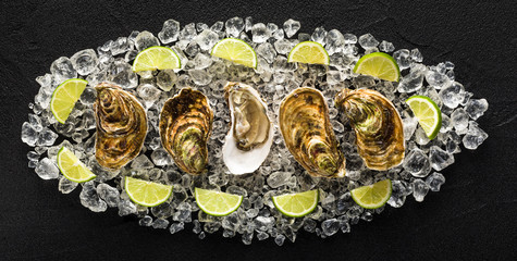 Fresh oysters on a black stone table top view