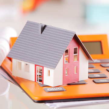 Close up Miniature House on Top of a Calculator