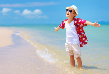 happy stylish boy enjoys life on summer beach