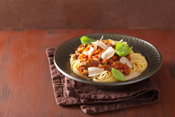 italian pasta spaghetti bolognese with basil on rustic table