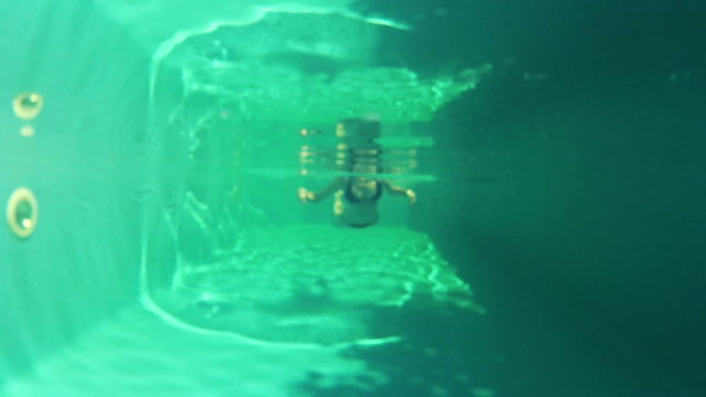 Pretty girl in bikini swimming in the pool underwater