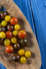 Colorful baby tomatoes on vibrant wooden background