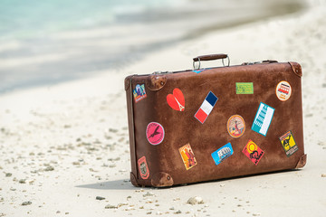 Travel vintage suitcase is alone on a beach