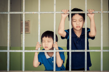 Two kid at the back of the iron bar