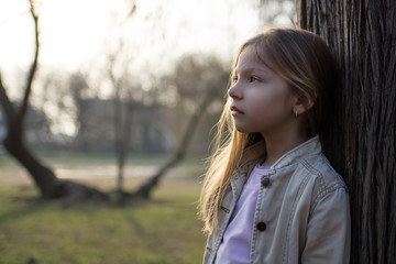 Pensive Little Girl Beside A Tree