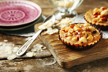 Mini cakes with nuts on wooden background