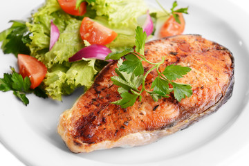 Tasty baked fish on plate close-up