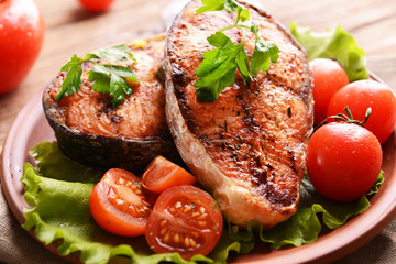 Tasty baked fish on plate on table close-up