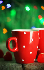 Two red cups on table on lights background