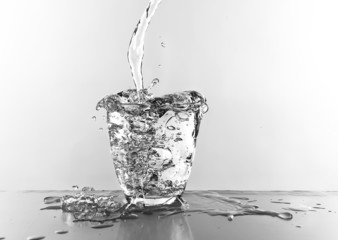 Water pouring in glass isolated on white