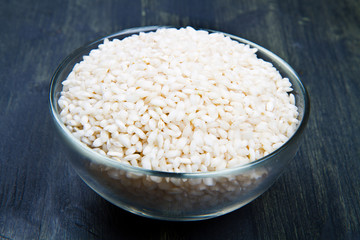 raw rice in glass bowl on wood table