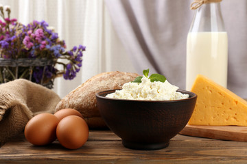 Tasty dairy products with bread and dry flowers