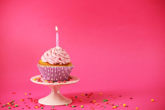Delicious cupcake on table on pink background