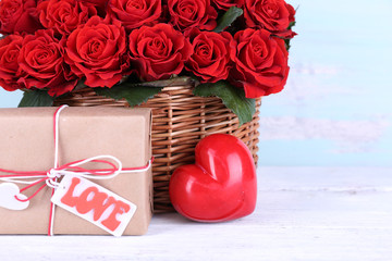 Bouquet of red roses in basket with present box