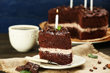 Delicious chocolate cake on table on blue background