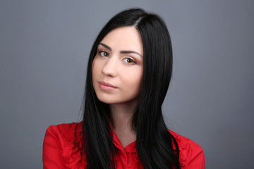 Portrait of young woman on grey background