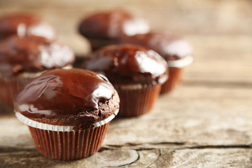 Tasty homemade chocolate muffins on wooden table