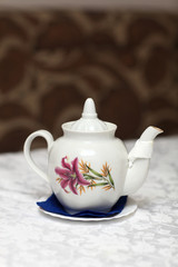 The white teapot with floral ornament