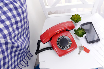 Retro phone on chair in room