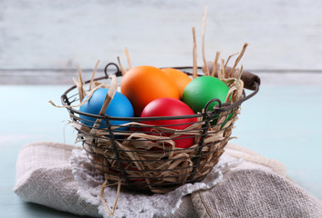Easter eggs in basket on wooden background