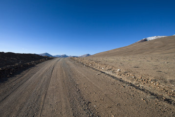 Beautiful landscape - country road in desert valley. The rocky m