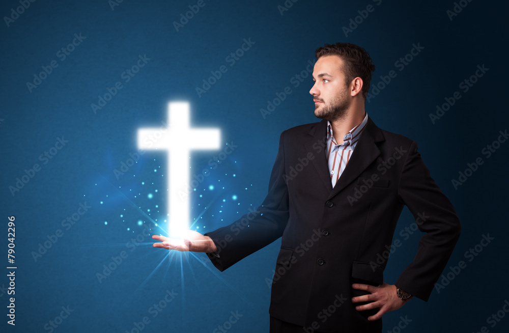 Wall mural Glowing cross in the hand of a businessman