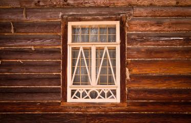 Window in a white frame on an old wooden wall. Toned