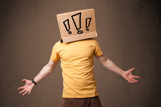 Young man gesturing with a cardboard box on his head with exclam