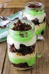 Pistachio, chocolate layered parfaits in mason jar glasses