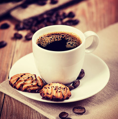 Cup of coffee and cookies on the table. Vintage retro hipster st