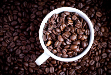 Coffee beans in coffee cup. Macro close up.