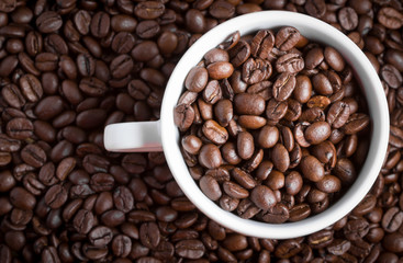 Coffee beans in coffee cup. Macro close up.