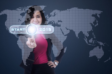 Female worker pushing start button