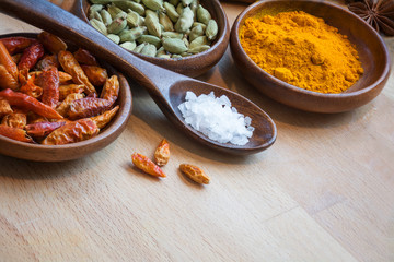 red chili, cardamom and curcuma in wodden bowls, spices as corne