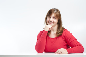 Middle-aged woman sitting with his elbows on the table..