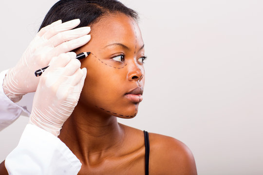 doctor marking young african woman face