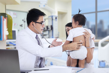 Pediatrician examines baby with stethoscope