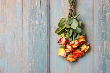 Bunch of orange roses hanging on wooden door