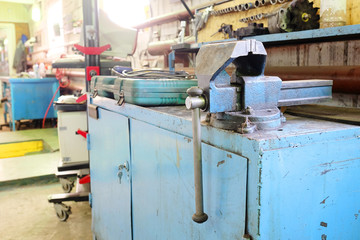 The image of a old vice on a metal workbench